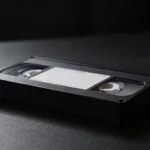 Cinta de vídeo antigua sobre una mesa oscura iluminada de lado