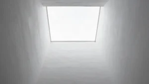 Patio estrecho y hondo visto desde abajo, con el cielo al fondo